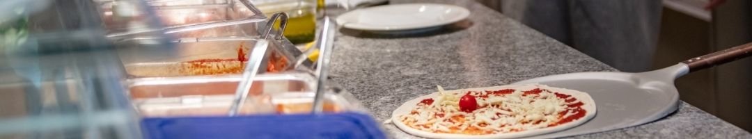 Pizza auf Pizzaschaufel und Gastronormbehälter