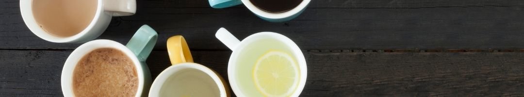 Tassen mit Tee, Kaffee, Cappuchino und Heißer Zitrone